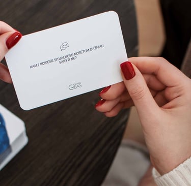 Moteris laiko rankose pokalbių kortelę poroms.