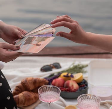 Dvi moterys pikniko metu naudoja saviterapijos korteles pokalbiams su savimi.