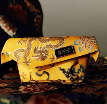 Luxury yellow clutch featuring dragon embroidery and metallic clasp.