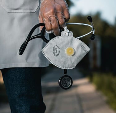 Healthcare worker holding a stethoscope and protective mask