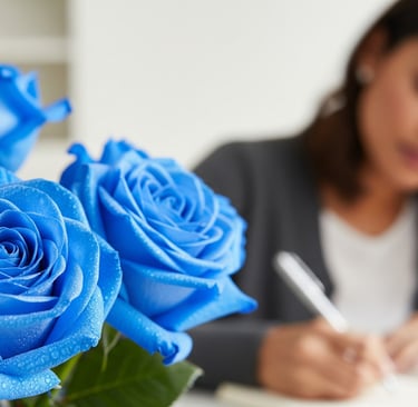blue roses close up as woman writes notes