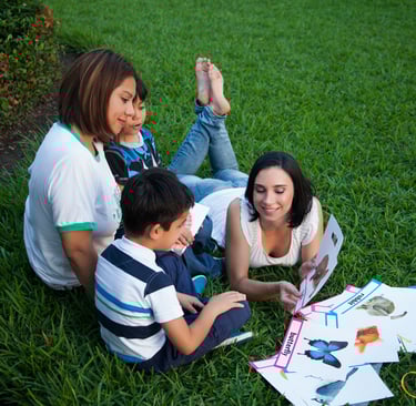 a family of four children sitting on the grass
