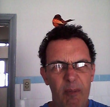 a man with glasses and a bird on his head