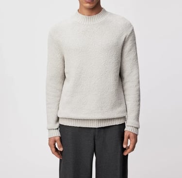 a man in a white sweater and pants with a grey sweater