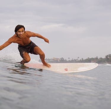 man riding surfboard looking into camera