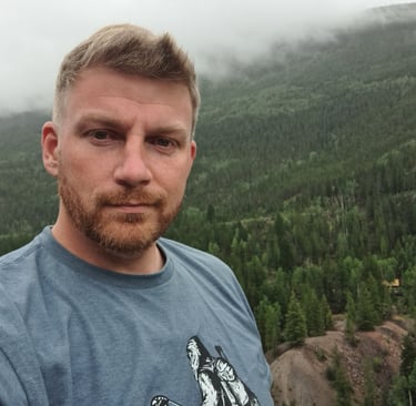Daniel Ferguson at the top of a mountain peak in Colorado.