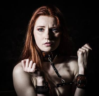 a woman in a leather bonde and leather cuffs