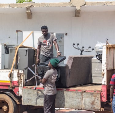 Three professional movers from TE Transporter Express load household appliances and furniture—includ