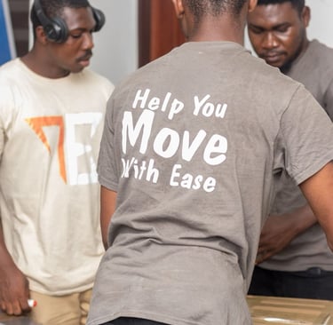 Three professional movers from Transporter Express team up to pack and tape cardboard boxes on a woo