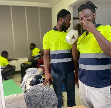 A team of four professional movers in yellow high-visibility polos with reflective stripes and "Safe