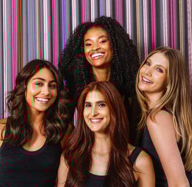 a imagem mostra 4 modelos sorrindo para a câmera com seus cabelos tratados com produtos Amend