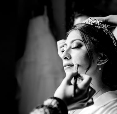 a woman getting her makeup done by a professional makeup artist