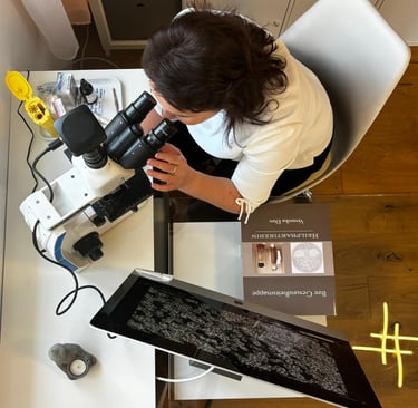a woman in a white shirt and black pants sitting at a table with a laptop