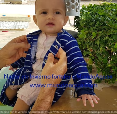 a baby in a blue jacket is being held by a man