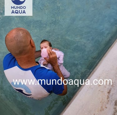 a man holding a baby in a pool