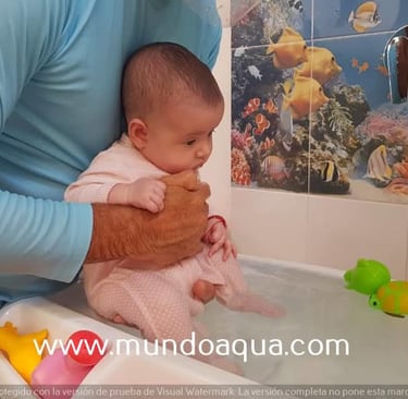 a man holding a baby in a bathtub