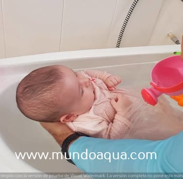 a baby in a tub with a man holding a pink cup