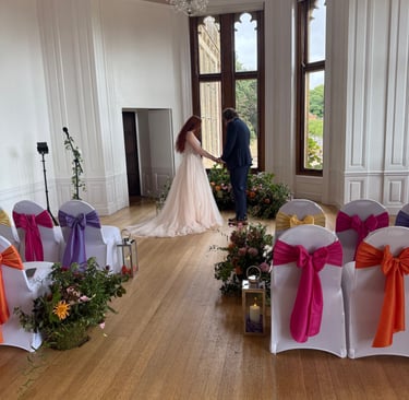 a bride and groom are standing in a room with white chairs