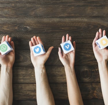 manos sujetando logos de redes sociales