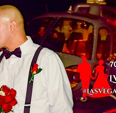 Newlywed couple kissing in front of a helicopter during a romantic Las Vegas wedding ceremony at night.