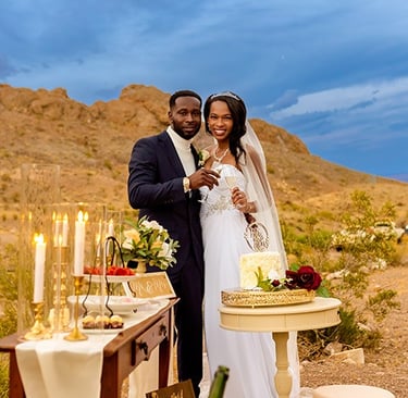a man and woman standing in front of a desert