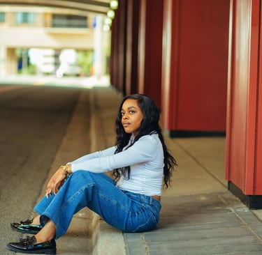black woman relaxing sitting on a street curb