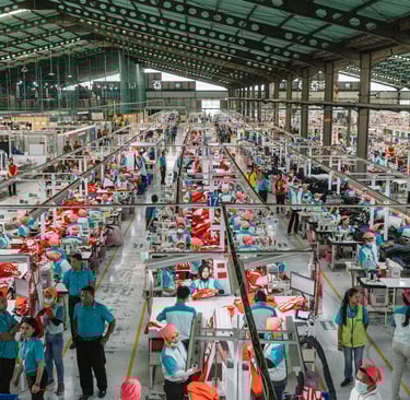 a factory floor with lots of people working on machines