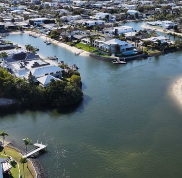Aerial view of luxury waterfront real estate with private docks along a coastal canal.
