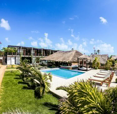 a pool with a thatched roof and a thatched umbrella