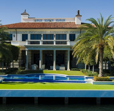 a large house with a pool and palm trees