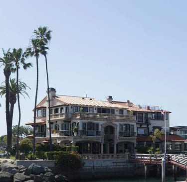 a large house with a dock and palm trees