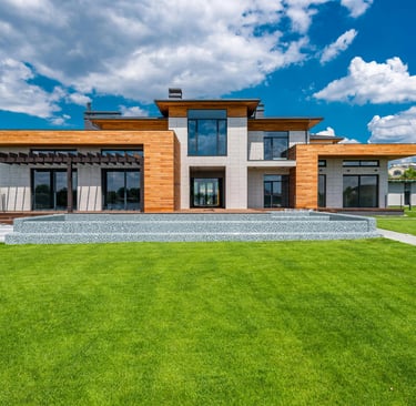 a large house with a lawn and a bench