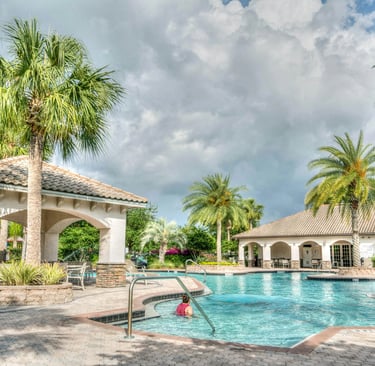 a pool with a gazeboar and palm trees