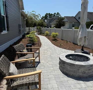 a patio with chairs and umbrellas in the yard