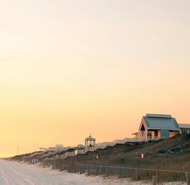 Luxury beachfront beach houses and pavilions on sand dunes during a golden sunset at Seaside, Florida.