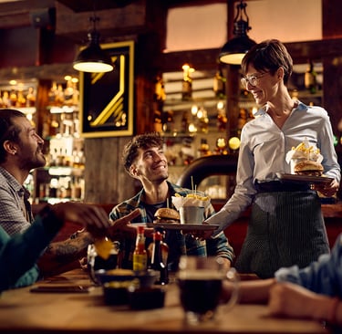 Smiling male doctor in white lab coat with stethoscope standing in a modern medical office.