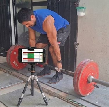 Una persona haciendo peso muerto mientras tiene su entrenamiento en el teléfono