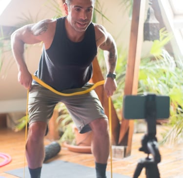 Un hombre realizando su entrenamiento mientras ve la rutina en su celular