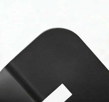 Close-up of a rounded corner on a matte black metal frame with a smooth finish.