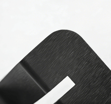 Close-up of a brushed black metal surface with a curved edge and smooth matte finish.