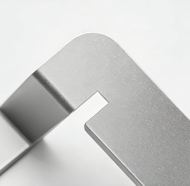 Close-up of a matte silver anodized aluminum bracket with a rounded corner and precision cutout.