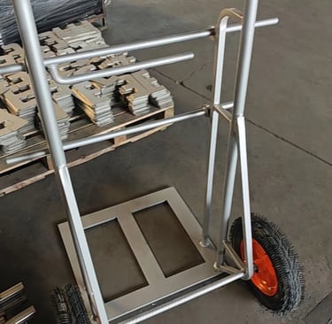 Heavy-duty steel industrial hand truck with pneumatic tires on a warehouse floor.