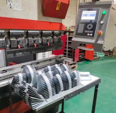 Industrial CNC press brake machine bending sheet metal parts in a manufacturing facility.