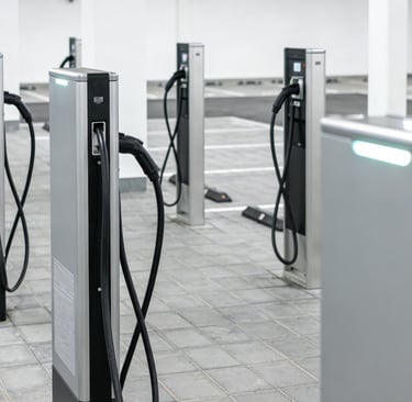 Row of modern electric vehicle charging stations in a bright underground parking garage.