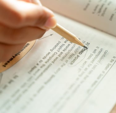 Close-up of a student circling answers in an English language textbook with a pencil while studying.