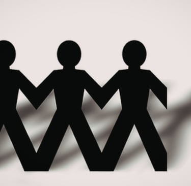Black paper chain people holding hands representing community teamwork and unity.