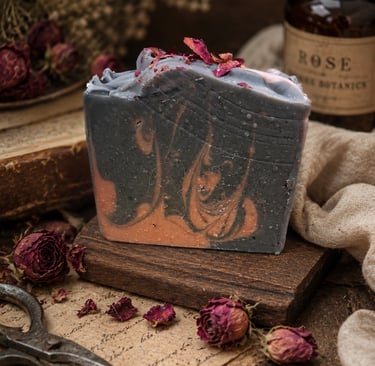 Handmade swirl bar soap with dried rose petals on a rustic wooden stand with vintage botanicals.