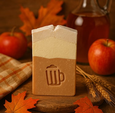 Handmade apple ale soap bar with maple leaves and fresh apples in a rustic fall setting.