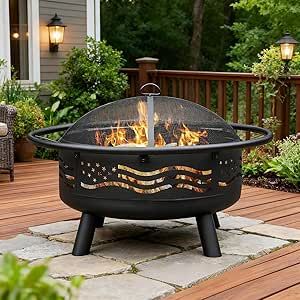 Round black steel wood-burning fire pit with American flag cutout on a backyard patio deck.