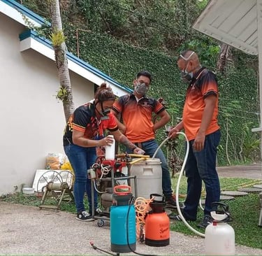 Jansen pest control team in orange uniforms preparing disinfection equipment and sprayers outdoors.
